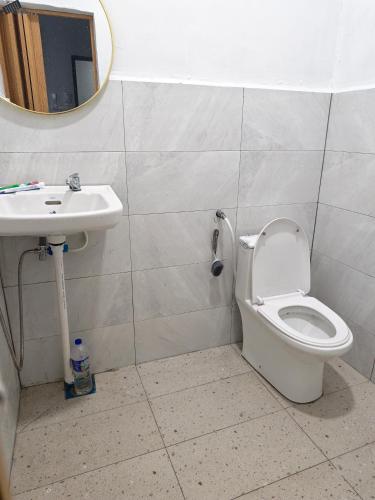 a bathroom with a toilet and a sink at Homestay Ayong in Parit Raja