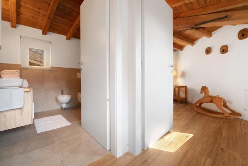 a bathroom with white walls and a wooden ceiling at Family House Il Butto in Erve
