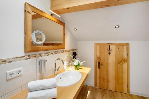 a bathroom with a sink and a mirror at Neubau - Ferienwohnung Waldblick in Höslwang