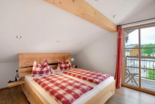 a bedroom with a bed and a large window at Neubau - Ferienwohnung Waldblick in Höslwang
