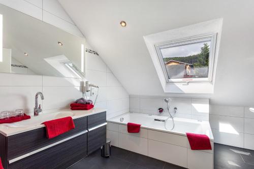 a white bathroom with a sink and a window at Haus Schönblick - "Fewo Sarina 2" in Willingen