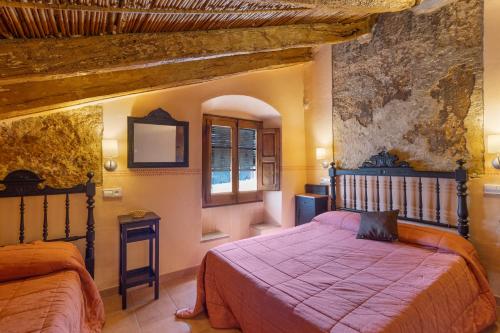 a bedroom with two beds and a window at Ca l'Emilli in Gélida