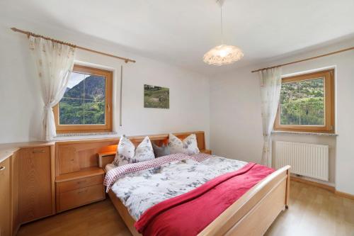 a bedroom with a bed and two windows at Hienerhof in Moso