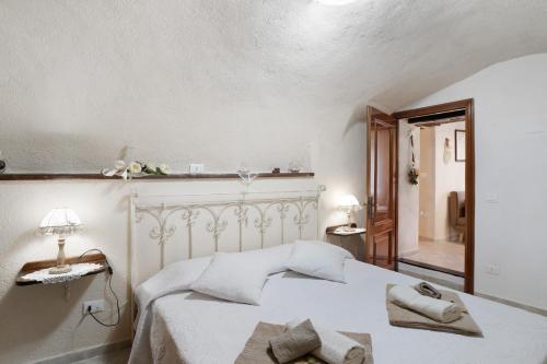 a bedroom with a white bed with towels on it at Agriturismo U' Spigu Nonna Annetta in Nasino