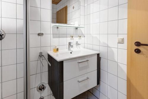 a white bathroom with a sink and a shower at Ferienwohnung Im Bohrer in Donaueschingen