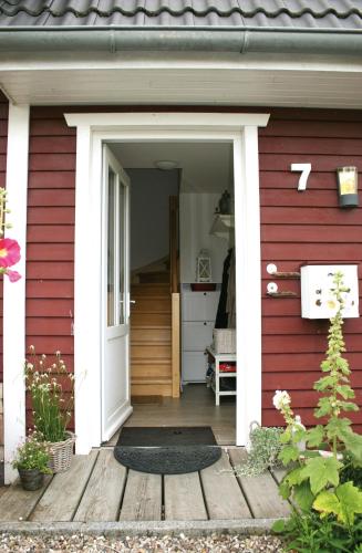 a red house with a white door and a porch at Ferienwohnung Traumblick in Reesdorf