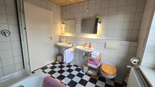 a bathroom with two sinks and a toilet and a tub at Kiepe im Münsterland in Nordwalde