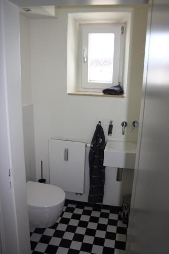 a bathroom with a toilet and a sink and a window at Haus Elbrächter - Erdgeschoss in Gstadt am Chiemsee