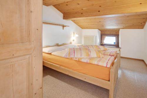 a bedroom with a bed with a wooden ceiling at Appartamenti Elisabetta n1 in Livigno