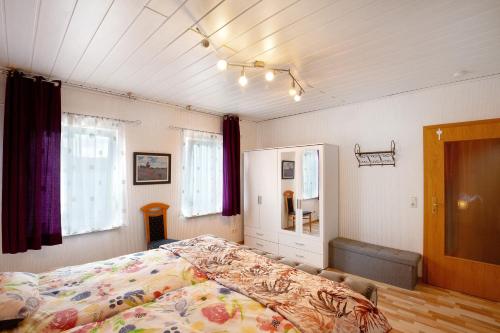 a bedroom with a bed and two windows at Ferienwohnung Failte in Niederselters