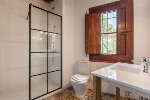a bathroom with a toilet and a sink and a mirror at Masia Sant Miquel in Canet de Mar