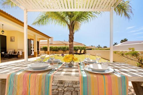 a wooden table with plates and wine glasses on a patio at Retiro Praia in Campo de Baixo