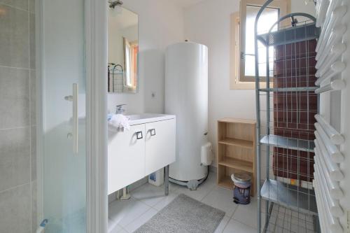 a white bathroom with a sink and a mirror at Chalet avec piscine privée in Savignac-les-Églises