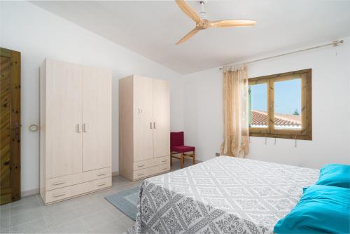 a bedroom with a bed and a ceiling fan at Azzurra in Orosei