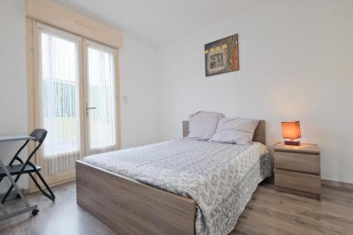 a white bedroom with a bed and a chair at Chalet avec piscine privée in Savignac-les-Églises