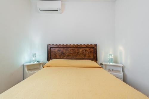 a bedroom with a large bed with two night stands at Casa Leo in Calasetta