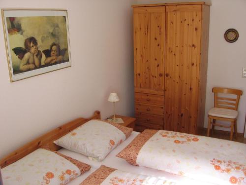 a bedroom with two beds and a painting on the wall at Ferienwohnung Blattmann in Sankt Peter