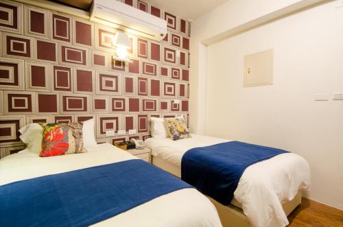 Successful 168 B&B في مدينة هوالين: سريران في غرفة بها جدار مزين بالصور