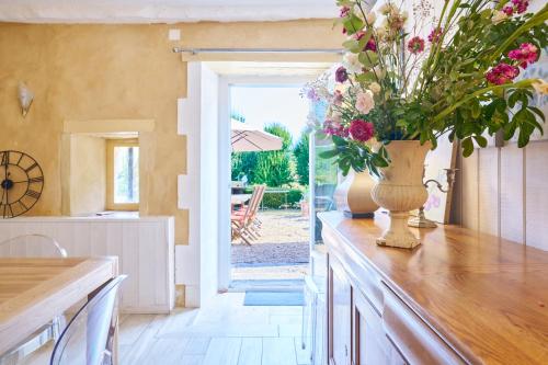 Un jarrón de flores en un mostrador de una cocina. en La Bastide 24, en Chapdeuil