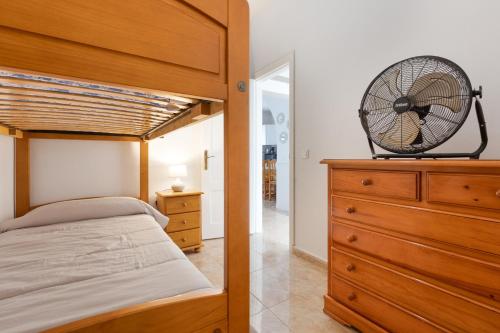 a bedroom with a bed and a fan on a dresser at Buganvilla in Pájara
