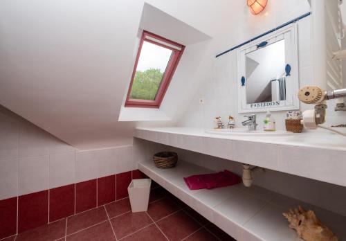 a bathroom with a sink and a mirror at Madig Azul Maison Piscine Chauffée in La Trinité-sur-Mer