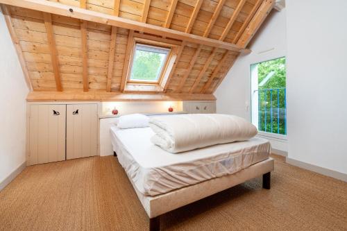 a bedroom with a bed and a wooden ceiling at Madig Azul Maison Piscine Chauffée in La Trinité-sur-Mer