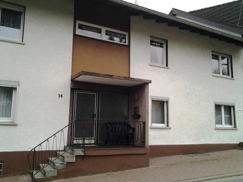Casa blanca con balcón y escalera en Ferienwohnungen Harling, en Erbach