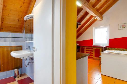 a bathroom with a white sink and a yellow wall at Ferienwohnung Saupp in Immenstaad am Bodensee