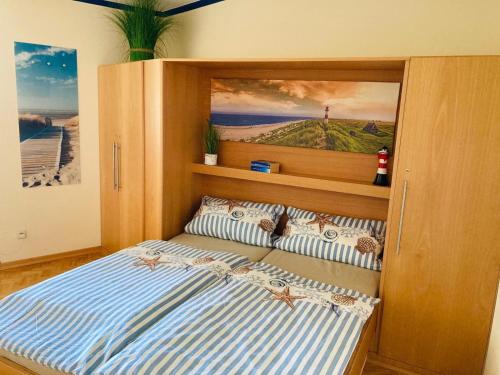a bedroom with a bed with a painting on the wall at 109 im Lord Nelson in Cuxhaven