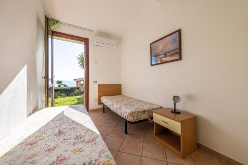 a bedroom with two beds and a window at Le Gemelle al 212 in Villaputzu