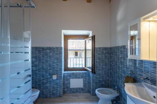 a bathroom with a toilet and a sink and a window at Artù in Tremosine Sul Garda