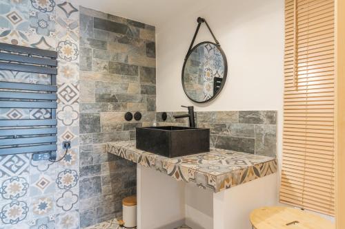 a bathroom with a sink and a mirror at Le Loft in Esparron