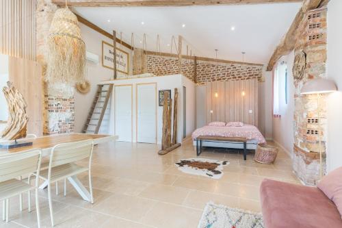 a room with a bed and a desk and a table at Le Loft in Esparron