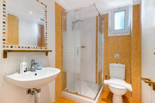 a bathroom with a toilet and a sink and a shower at Villa Captain Fotis 3 in Póndi