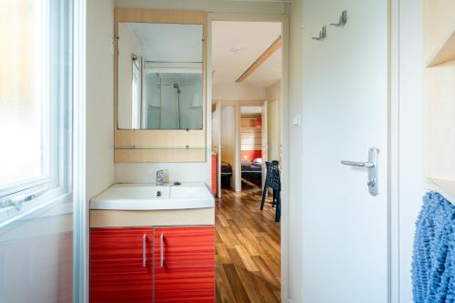 a bathroom with a white sink and a red cabinet at Euro Mobil B16 in Boofzheim