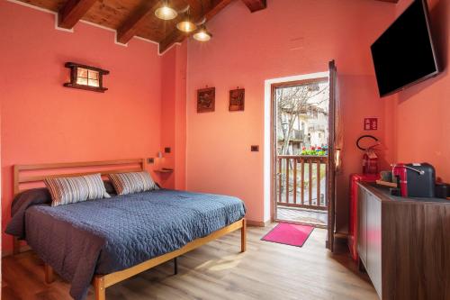 a bedroom with a bed and a television and a balcony at Petite Maison Tillier in Fenis