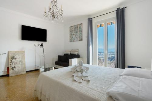 a white bedroom with a bed and a couch at Casa Merlino in Biassa