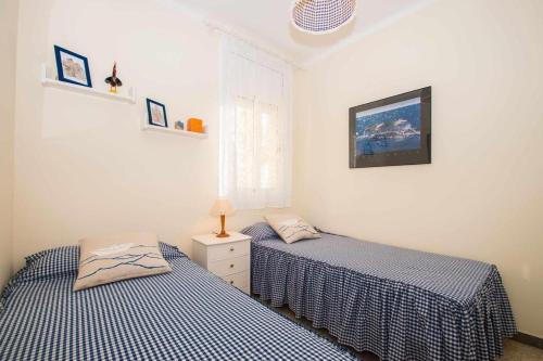 two twin beds in a room with two beds sidx sidx sidx at Maresme Beach Apartment in Canet de Mar