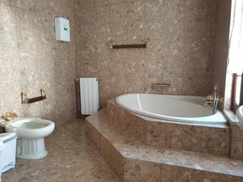 a bathroom with a bath tub and a toilet at Casa do Terreiro in Barqueiros