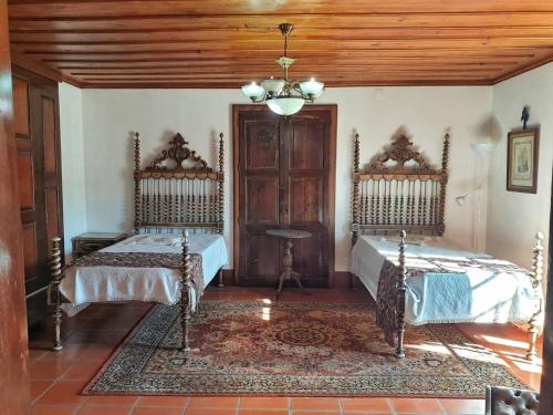 a bedroom with two beds and a wooden ceiling at Casa do Terreiro in Barqueiros