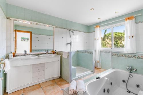 a bathroom with two sinks and a tub and a shower at Sa Torre in Llucmajor