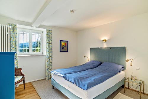a bedroom with a blue bed and a window at Merkurblick in Baden-Baden