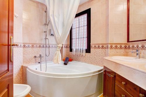 a bathroom with a tub and a toilet and a sink at Vista de Lobos in Corralejo