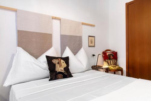 a bedroom with a white bed with a pillow on it at Casa Maria in Porto Ceresio