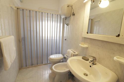 a white bathroom with a sink and a toilet at Casa Primus Torre Santo Stefano in Otranto