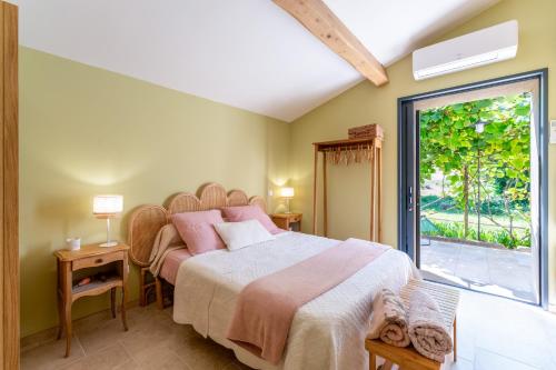a bedroom with a large bed and a window at Tilleul enchanté in Malaucène