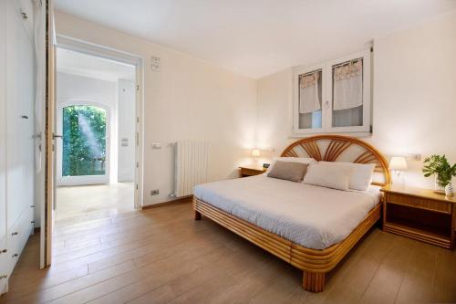 a bedroom with a large bed and a wooden floor at Villa Savi Lake View and Pool in Torri del Benaco