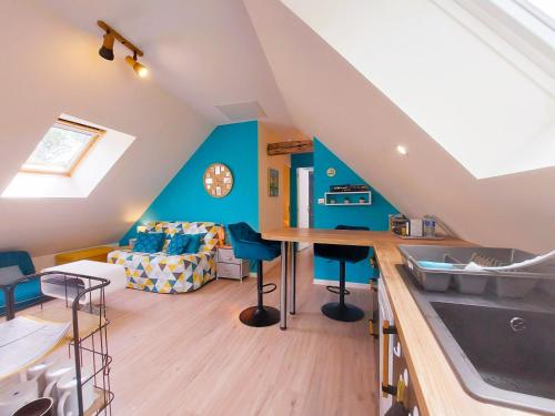 a kitchen and living room with blue walls at le Nid perché in Brou