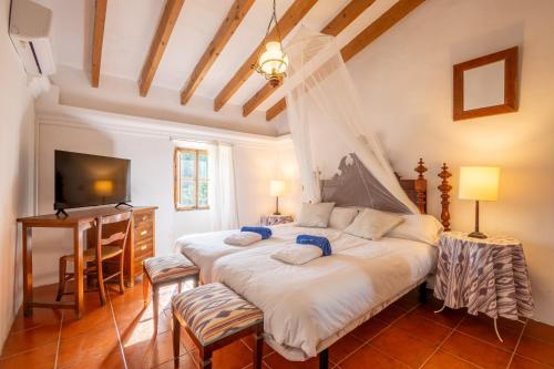 a bedroom with two beds and a desk at S' Oratge in Islas Baleares