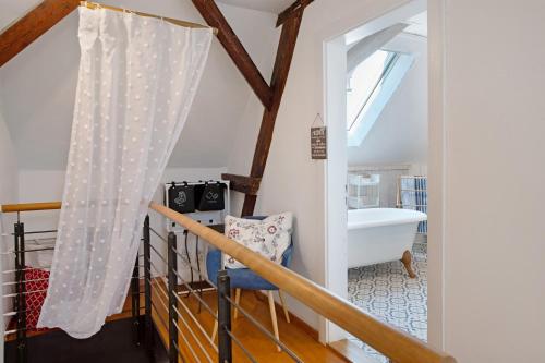 a bathroom with a staircase with a tub and a window at Ferienappartments Nähe Schweiz in Kandern